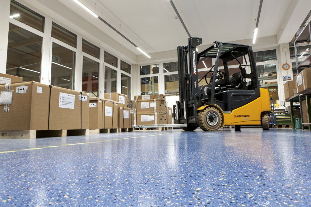 Boden, der Gabelstaplern und anderen Flurförderfahrzeugen stand hält: norament grano, im Einsatz bei der Schleuniger AG, Thun