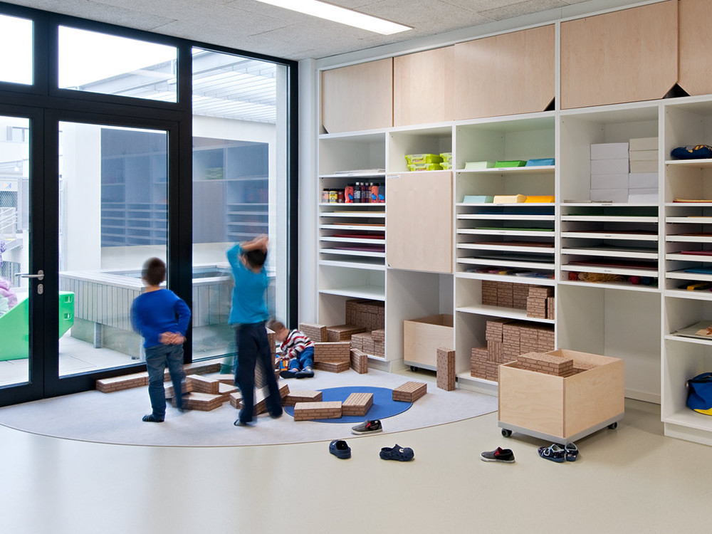 Le sol joue un rôle central dans le concept du bâtiment de l'école: les enfants utilisent celui-ci ´qgalement pour s'asseoir, travailler, apprendre, écrire et peindre.