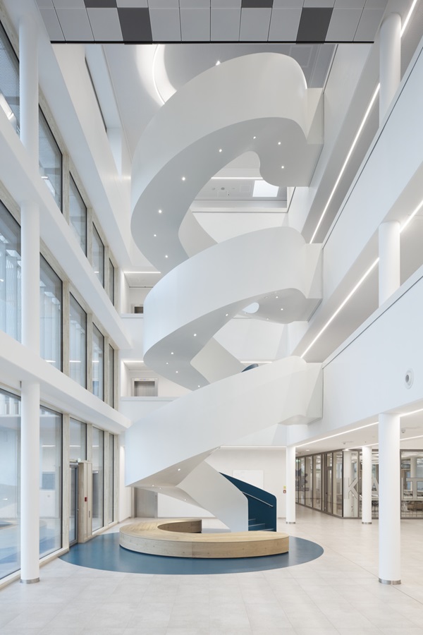 eine assymetrisch gewendelte Treppe verbindet wie eine Skulptur vier Etagen