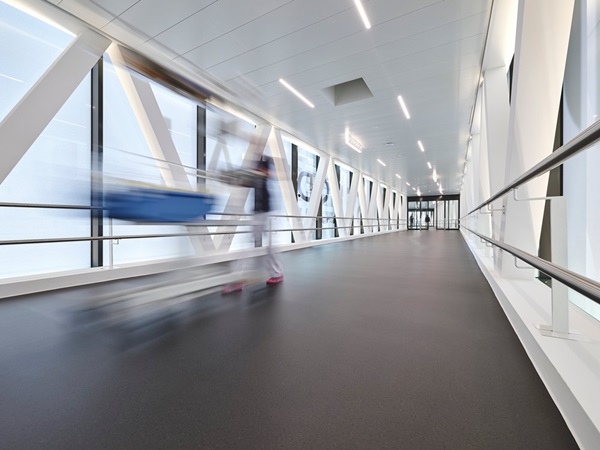 Connecting corridor in the hospital, a nurse pushing a trolley can be recognised in a blur
