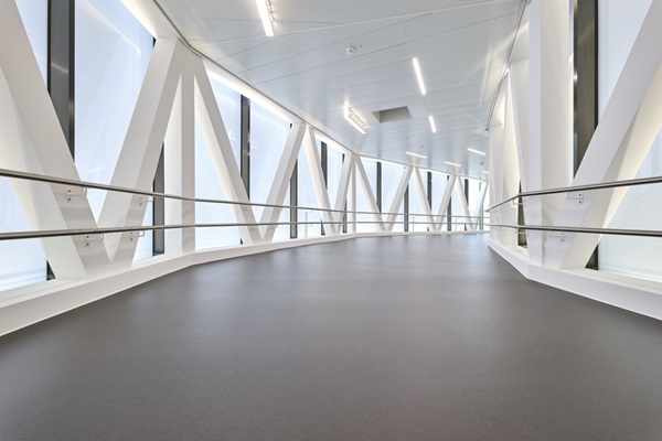 Dynamische Biegung im Verbindungsgang, der die Bauten des Spitals verbindet. Links und rechts Fensterfronten