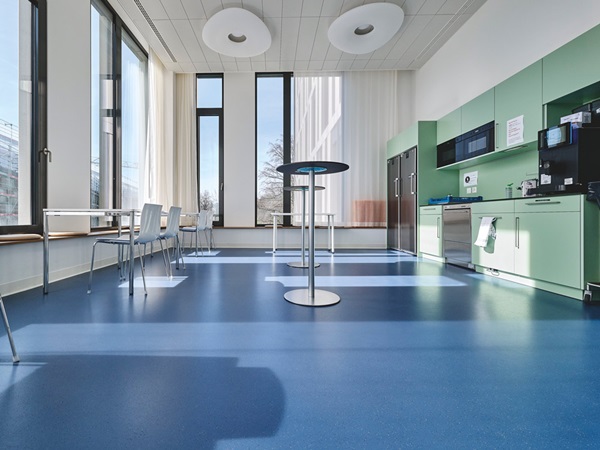 Break/recreation room in hospital with kitchenette, bistro tables and seating